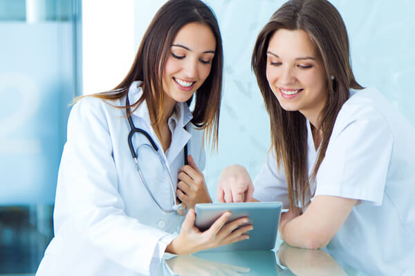 medical and nurse looking for something on a digital tablet at the hospital